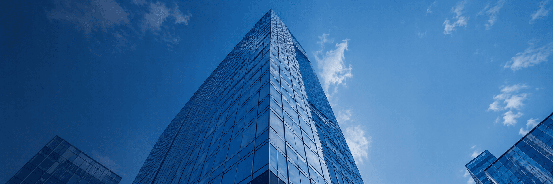 Blue glass office towers rising into a clear sky